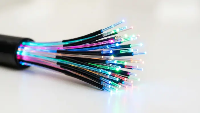 Fiber optic cables glowing with light pulses representing broadband internet speed